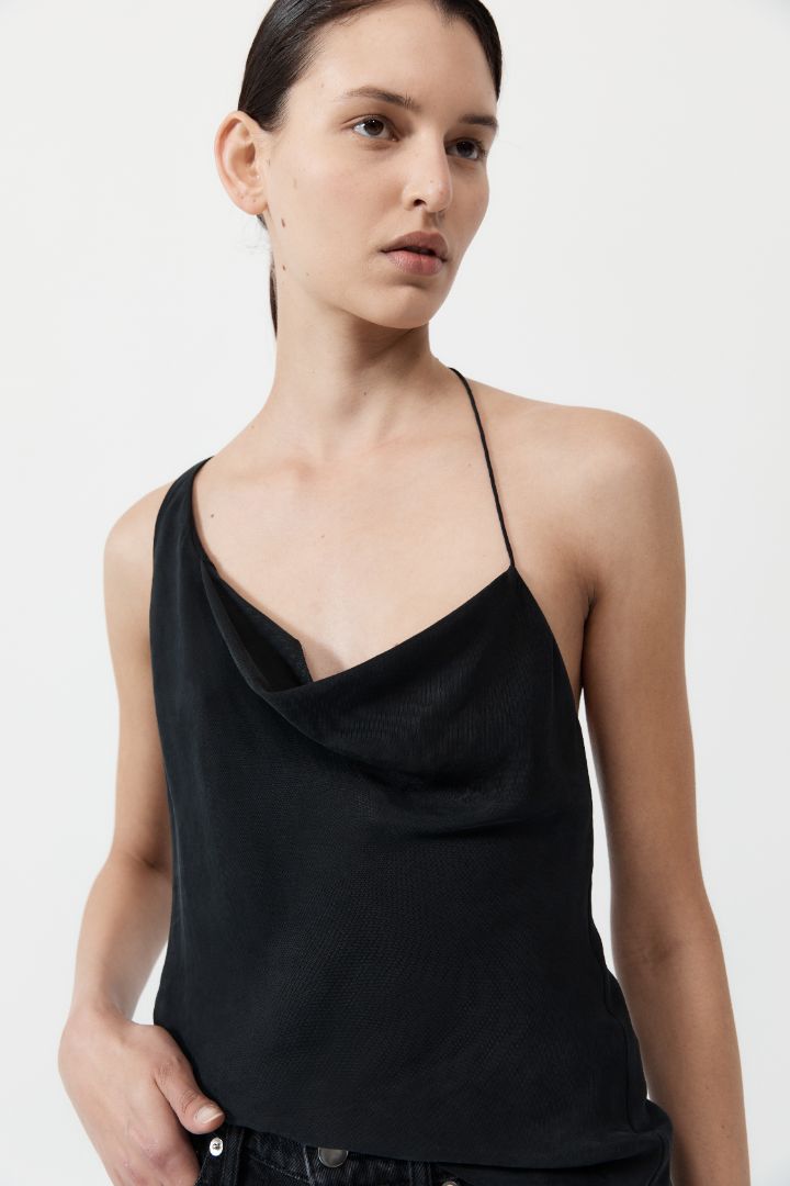 The ST. AGNI Asymmetrical Drape Top in Black from The New Trend.
